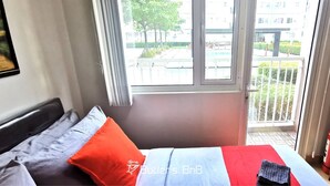 Une chambre d’hôtel avec un lit, une fenêtre et une vue sur l’extérieur.