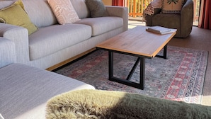 A cozy living room with a sofa, a coffee table, and a rug.