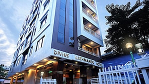 A multi-story hotel with a prominent entrance and a sign reading "DIVINE KATHMANDU HOTEL". - Divine Kathmandu Hotel (Kathmandu)