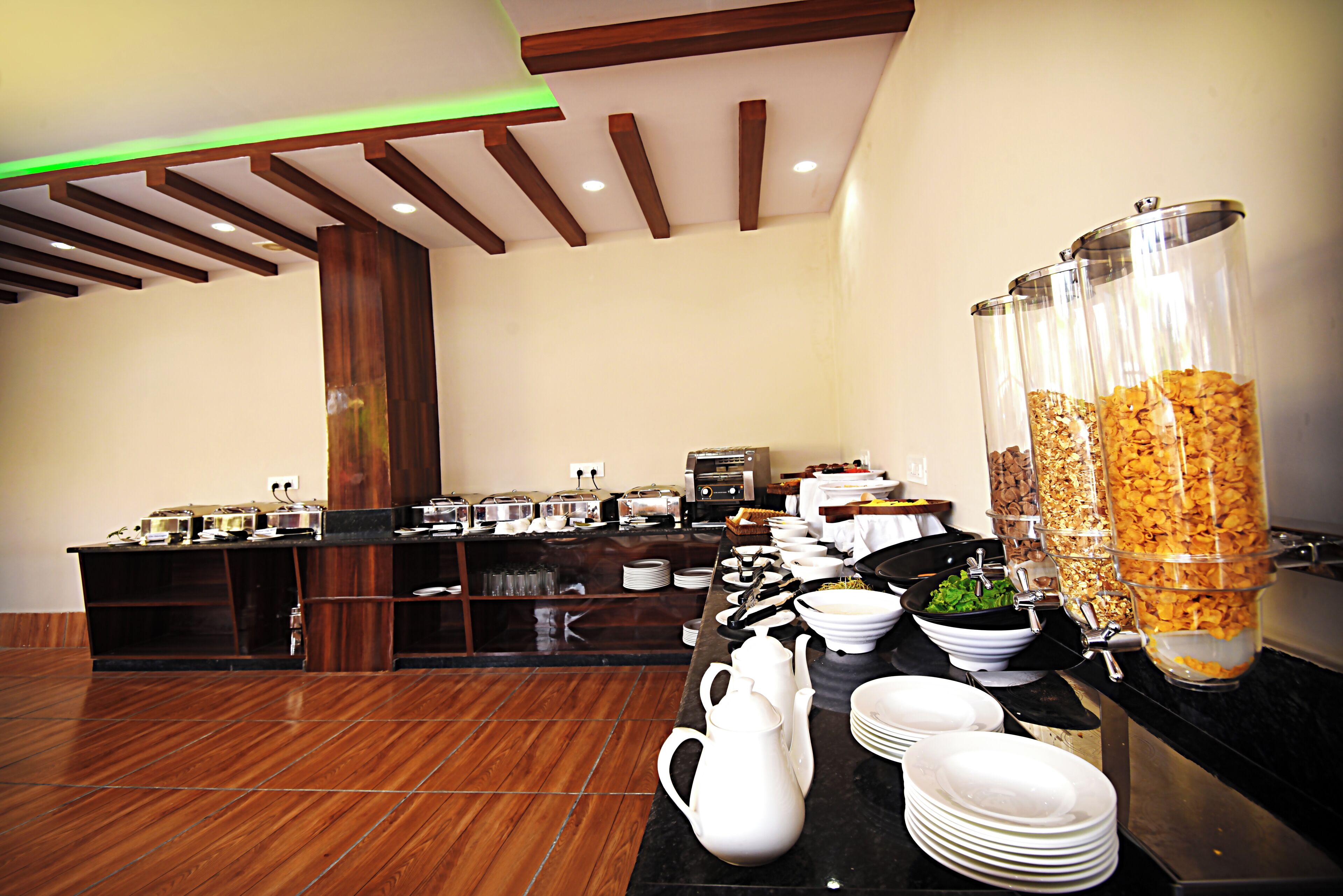 A buffet setup with various food items and serving utensils.
