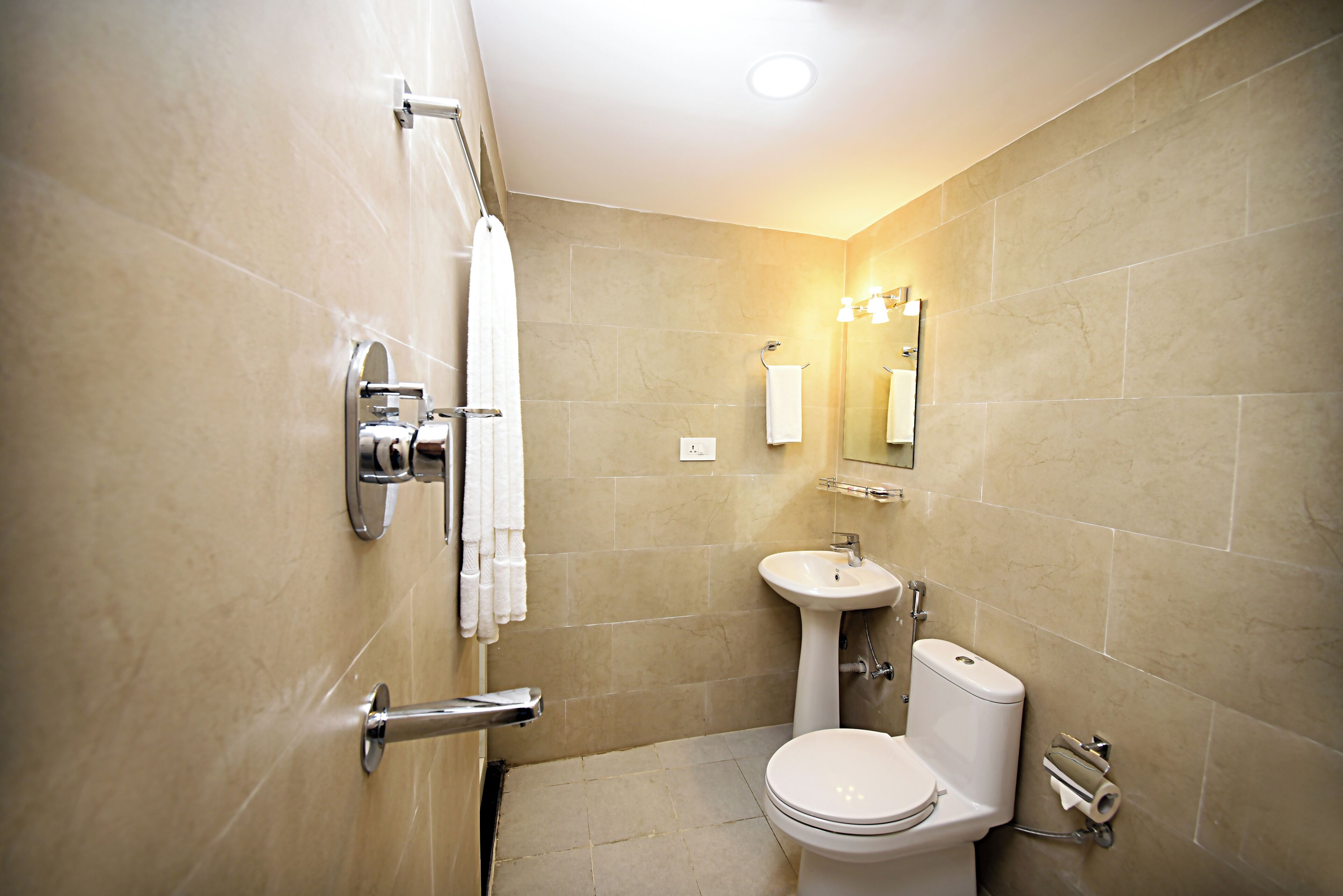 Ein modernes Badezimmer mit Toilette, Waschbecken und Handtuchhalter.