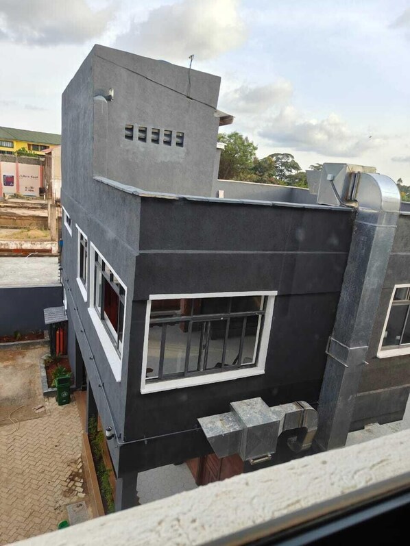 A modern building with a flat roof, large windows, and a visible satellite dish.