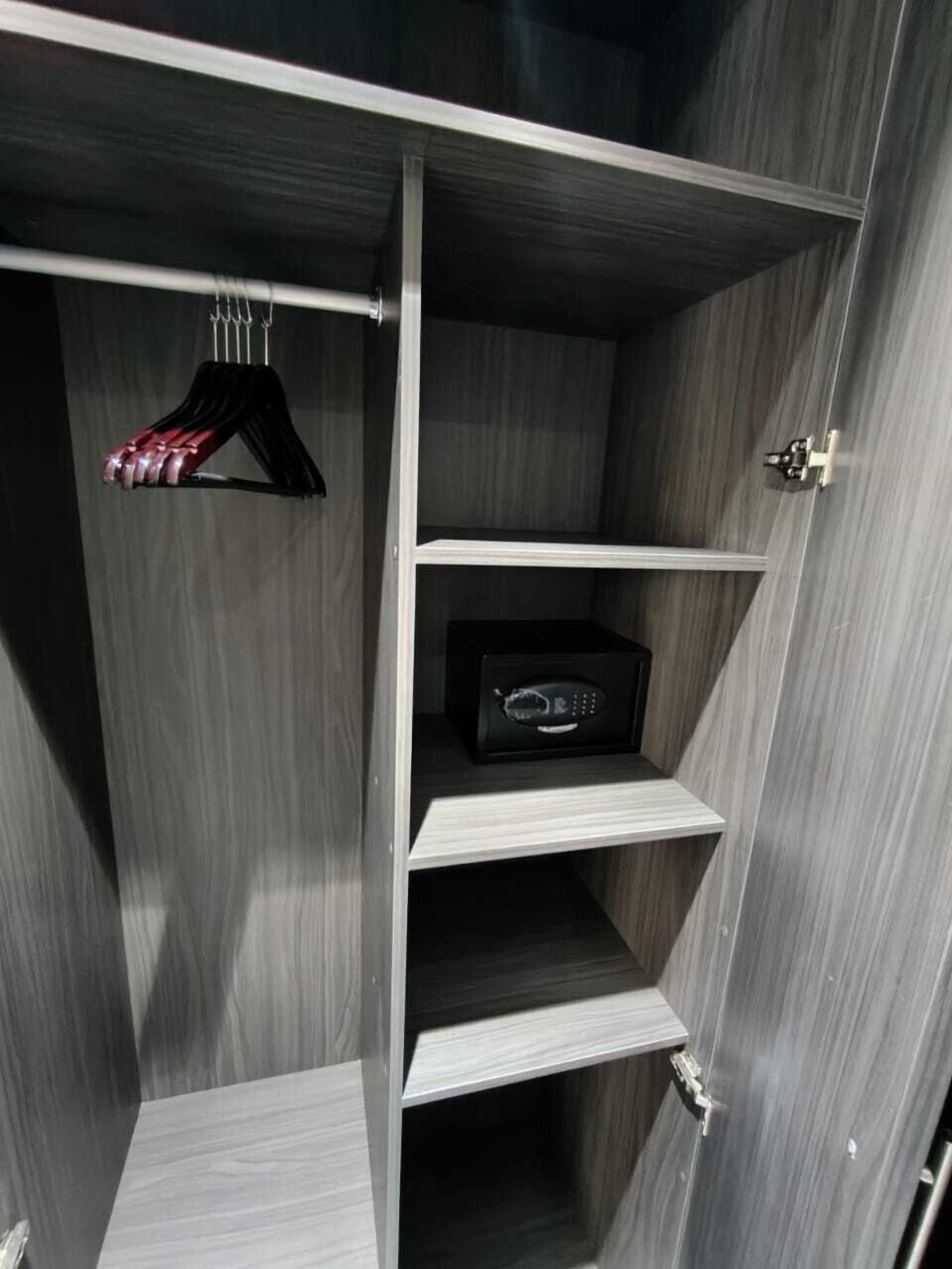 Un vestidor con estantes de madera y una barra para colgar.