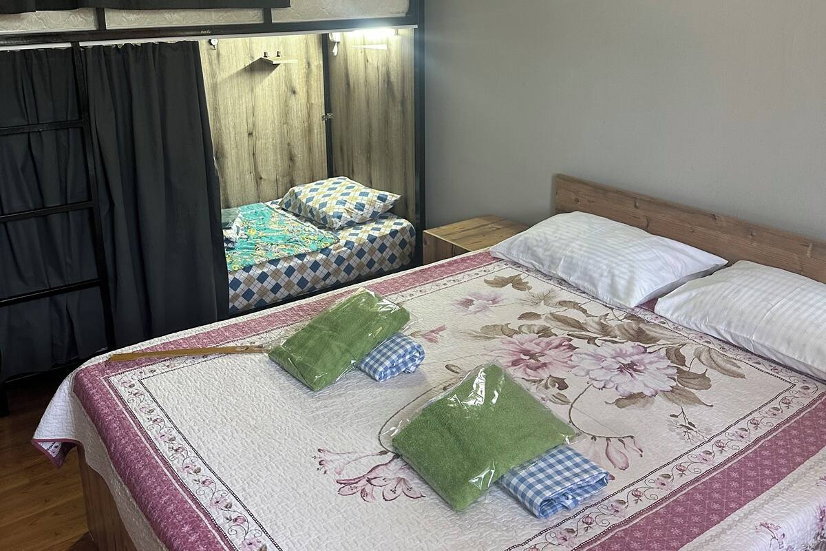 A bedroom with a bed, a clock on the wall, and a wardrobe.