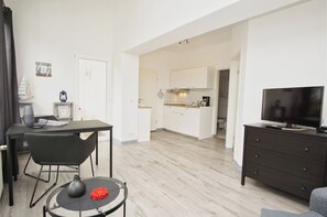A modern apartment with a dining area, kitchen, and living space.