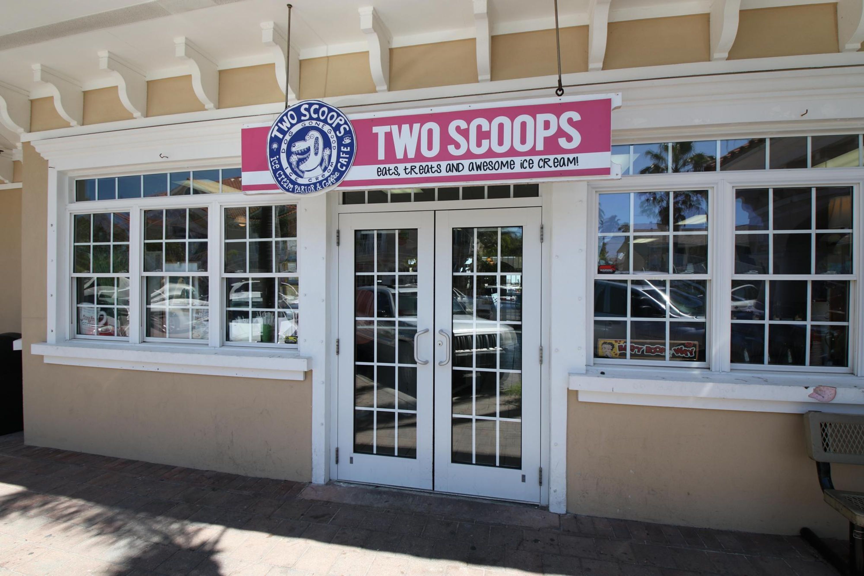 A storefront with a sign reading "TWO SCOOPS" and a window display.