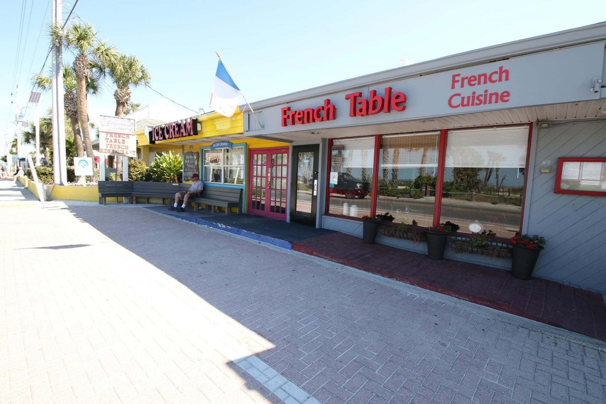 A storefront with a sign reading "French Table French Cuisine" and a smaller sign for "Ice Cream French Restaurant."