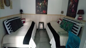 A room with two single beds, a small stool, and a chair. - Studio Meublé Indépendant Dans un Ancien Moulin (Ceton)