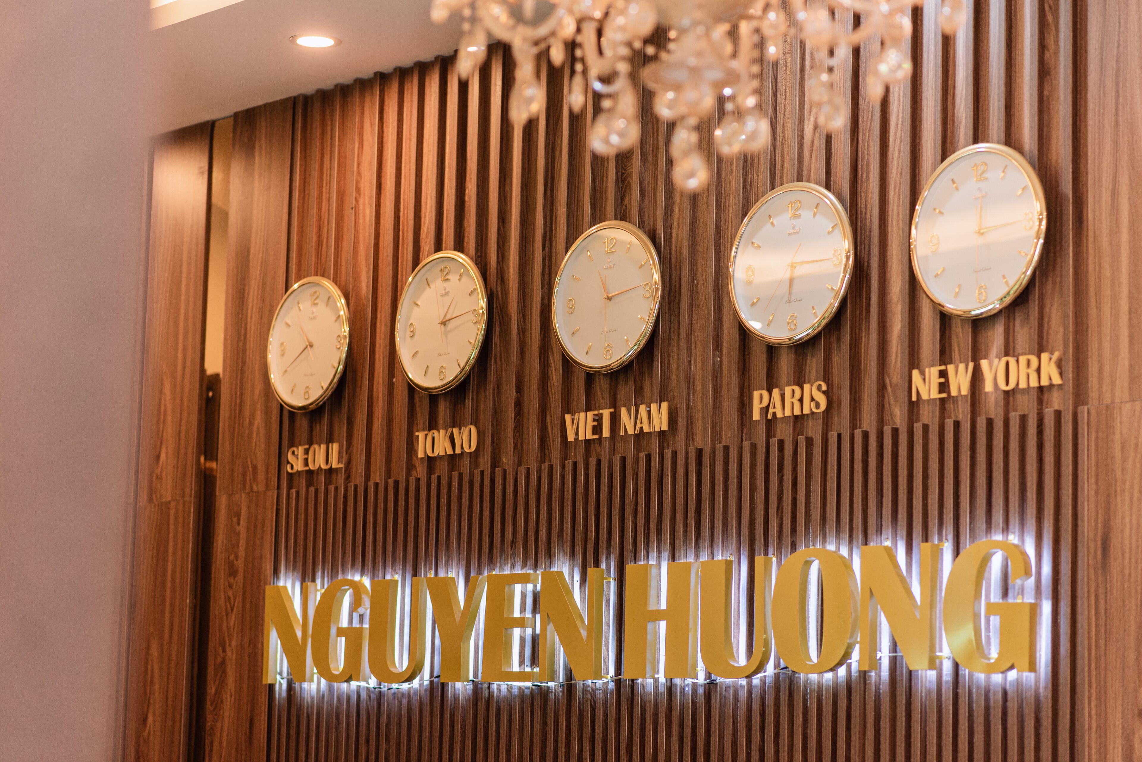 Un mur orné d’horloges indiquant différentes heures et portant les noms de villes comme Séoul, Tokyo et New York.