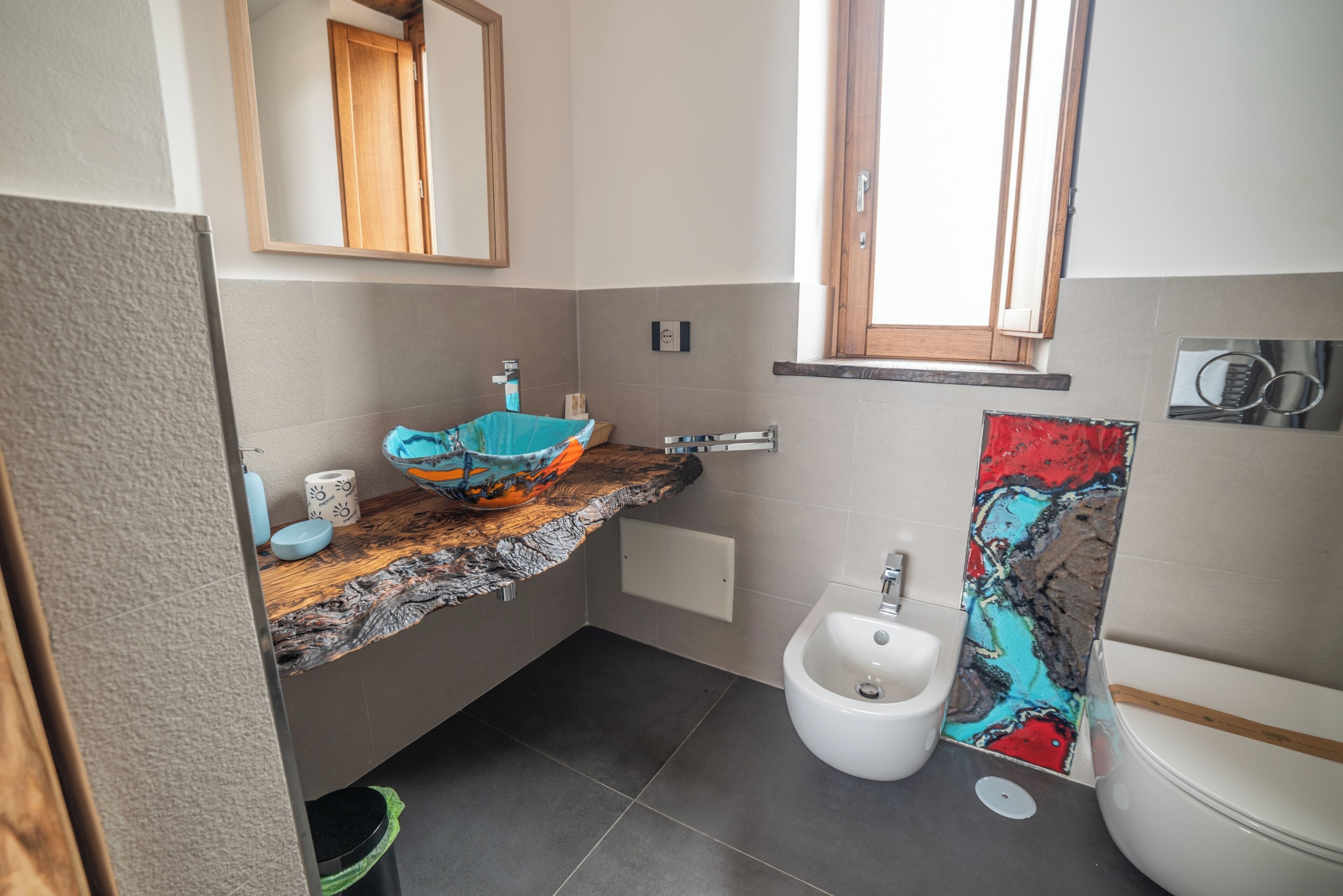 Une salle de bain avec un plan de toilette en bois, un lavabo, un bidet et des toilettes.