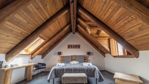 A bedroom with a sloped ceiling, a bed, a desk, and a chair. - Antichi Orti Del Sole (Agerola)