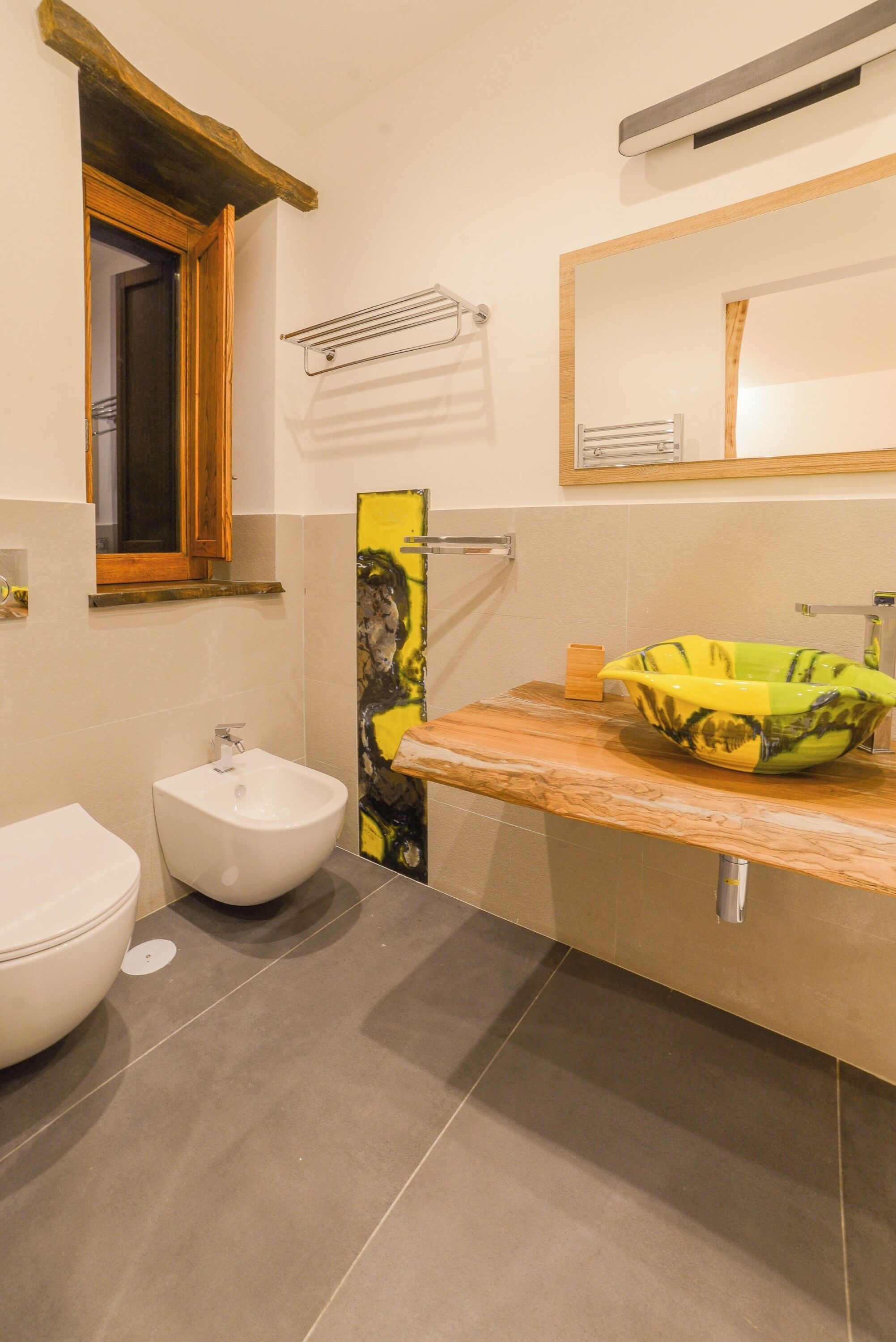 A bathroom with a white sink, a bidet, and a mirror above the sink.
