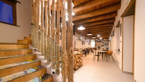 A staircase with wooden steps and a glass railing, leading to a dining area with tables and chairs. - Antichi Orti Del Sole (Agerola)