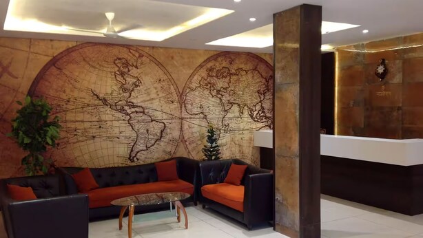A lobby with a large world map mural, a reception desk, and a seating area with sofas and a coffee table.