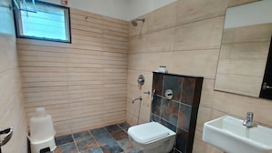 A bathroom with a toilet, sink, and shower.