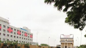 A pathway leading to a building with a sign reading "Priyanjali Garden".