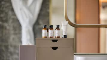 A bathroom vanity with a beige cabinet, a mirror, and three Perricone MD products on top.