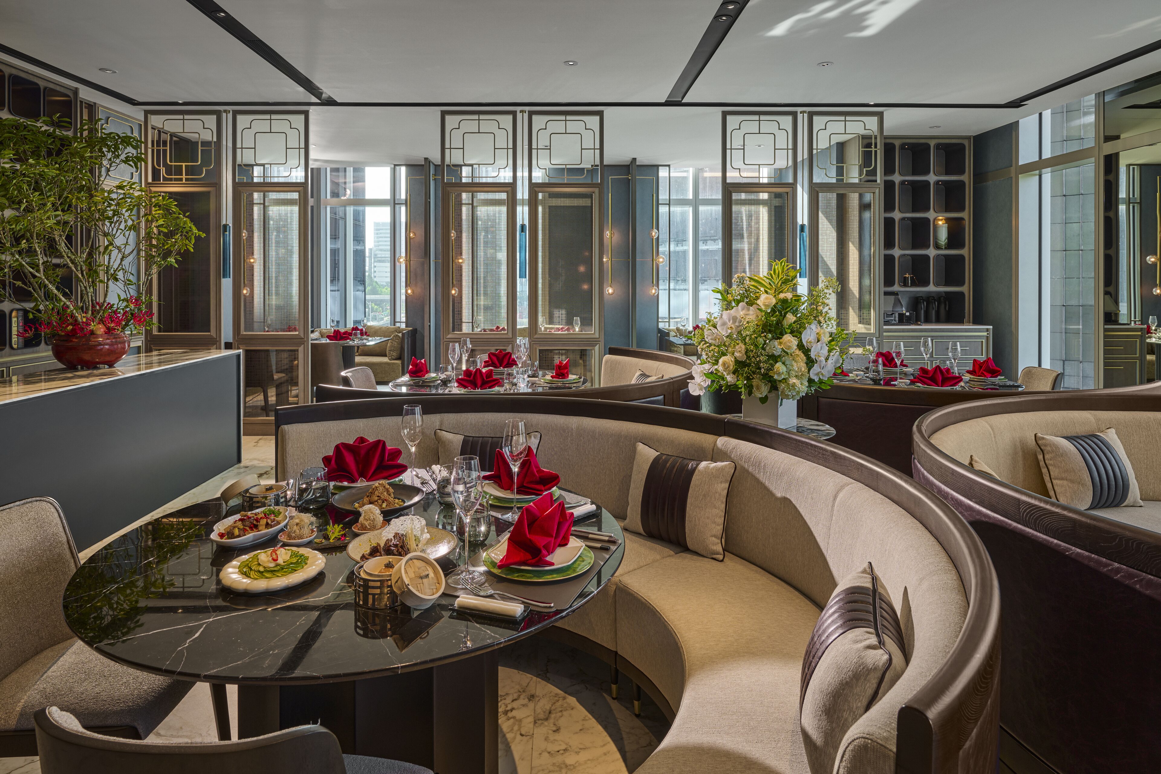 A modern dining area with a round table set for a meal, surrounded by comfortable seating.