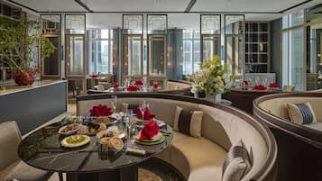A modern dining area with a round table set for a meal, surrounded by comfortable seating.