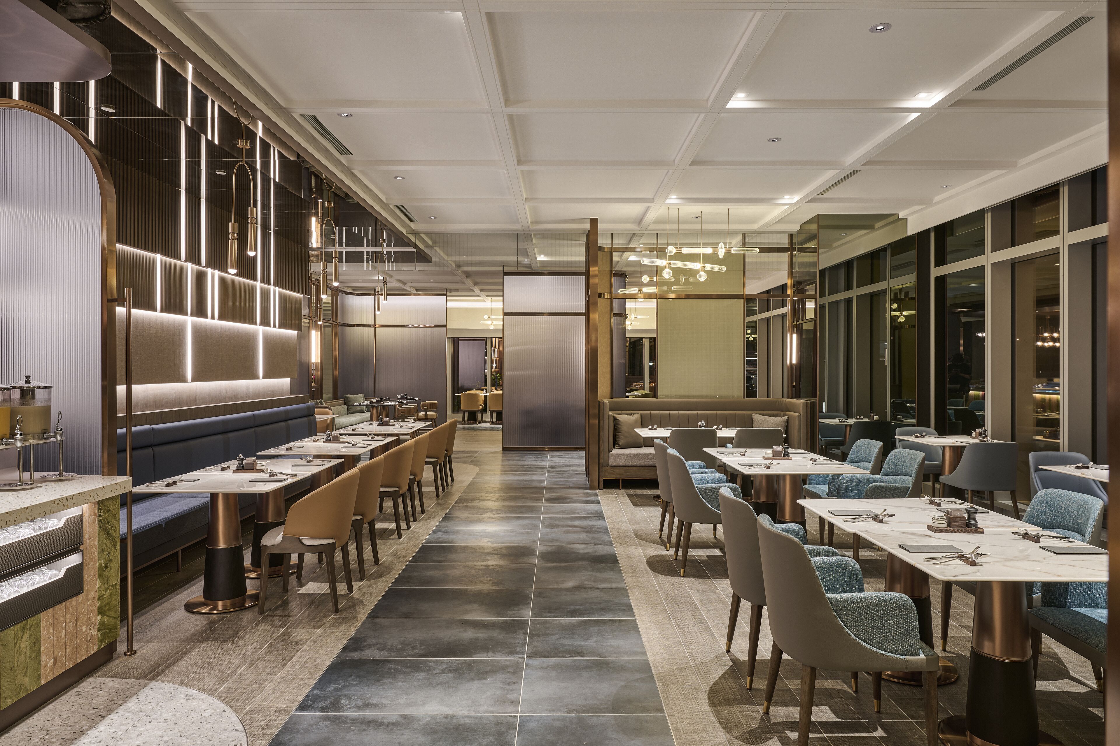 Un restaurant moderne doté de longues tables conviviales, de banquettes et d’un bar central.
