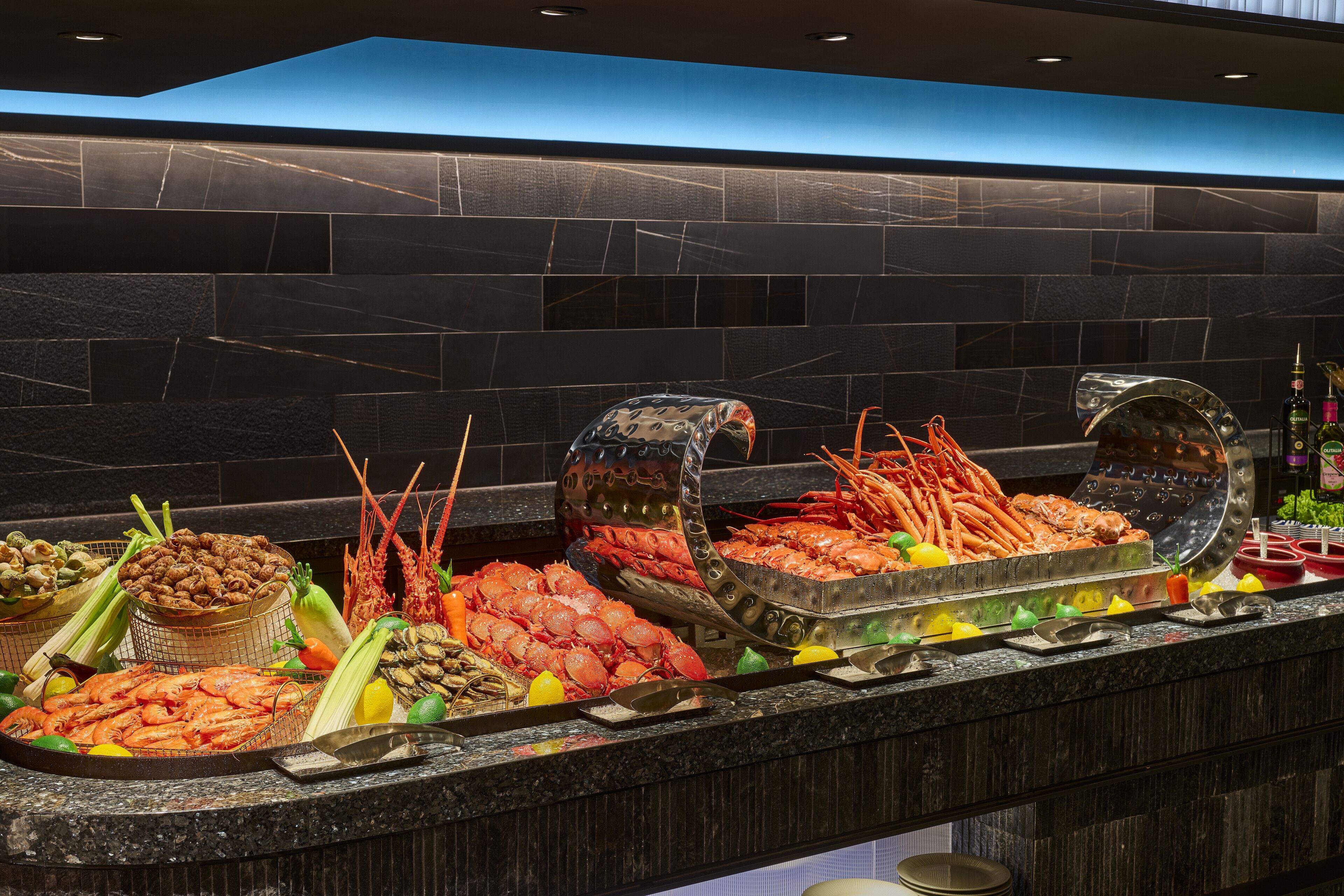 A seafood buffet with various types of seafood displayed on a counter.