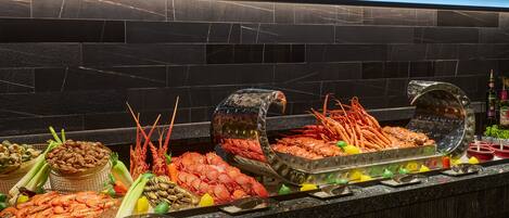 A seafood buffet with various types of seafood displayed on a counter.