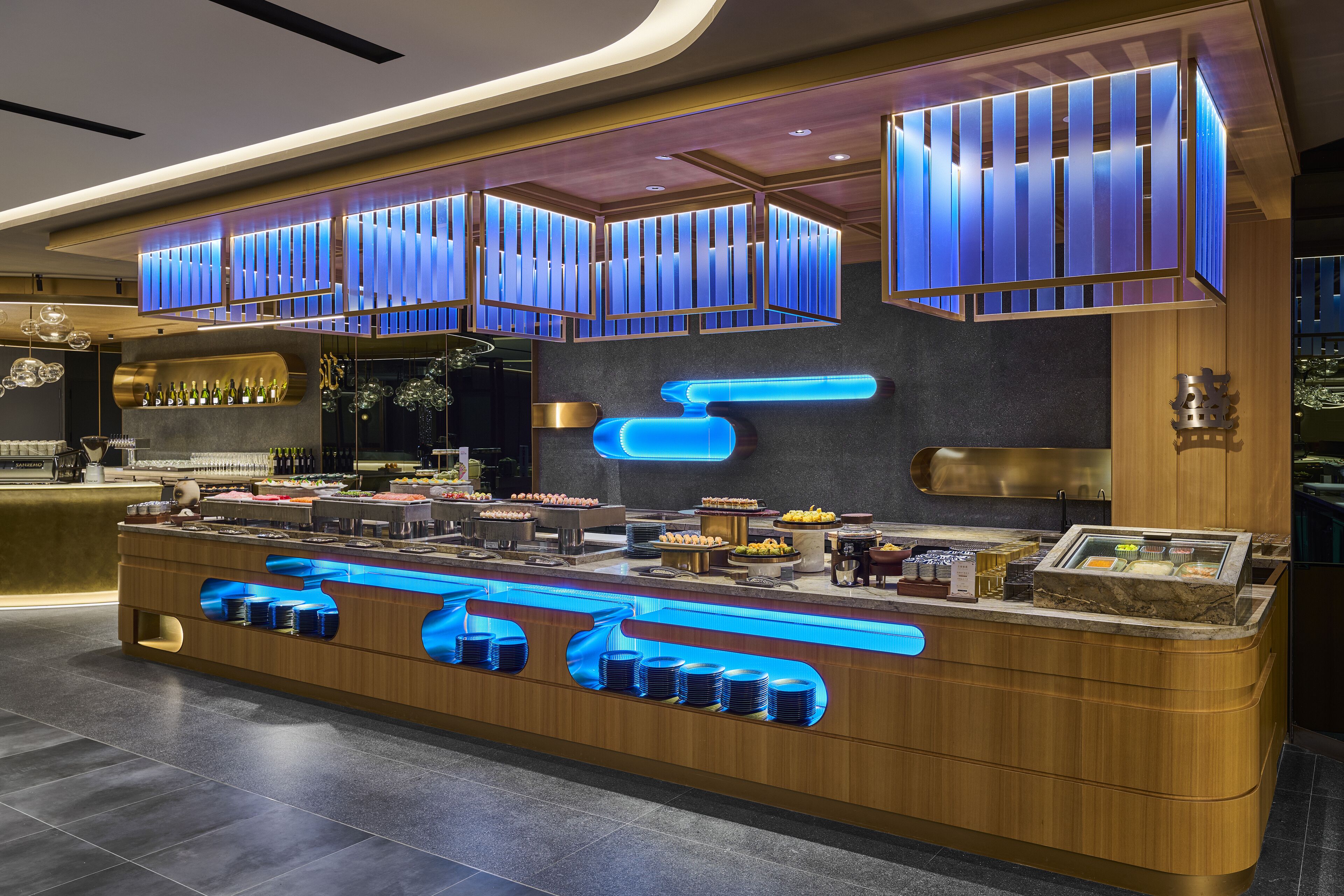 A modern buffet setup with illuminated blue accents and a variety of food items.