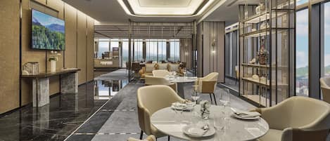 A modern dining area with round tables, beige chairs, and a large TV on the wall.