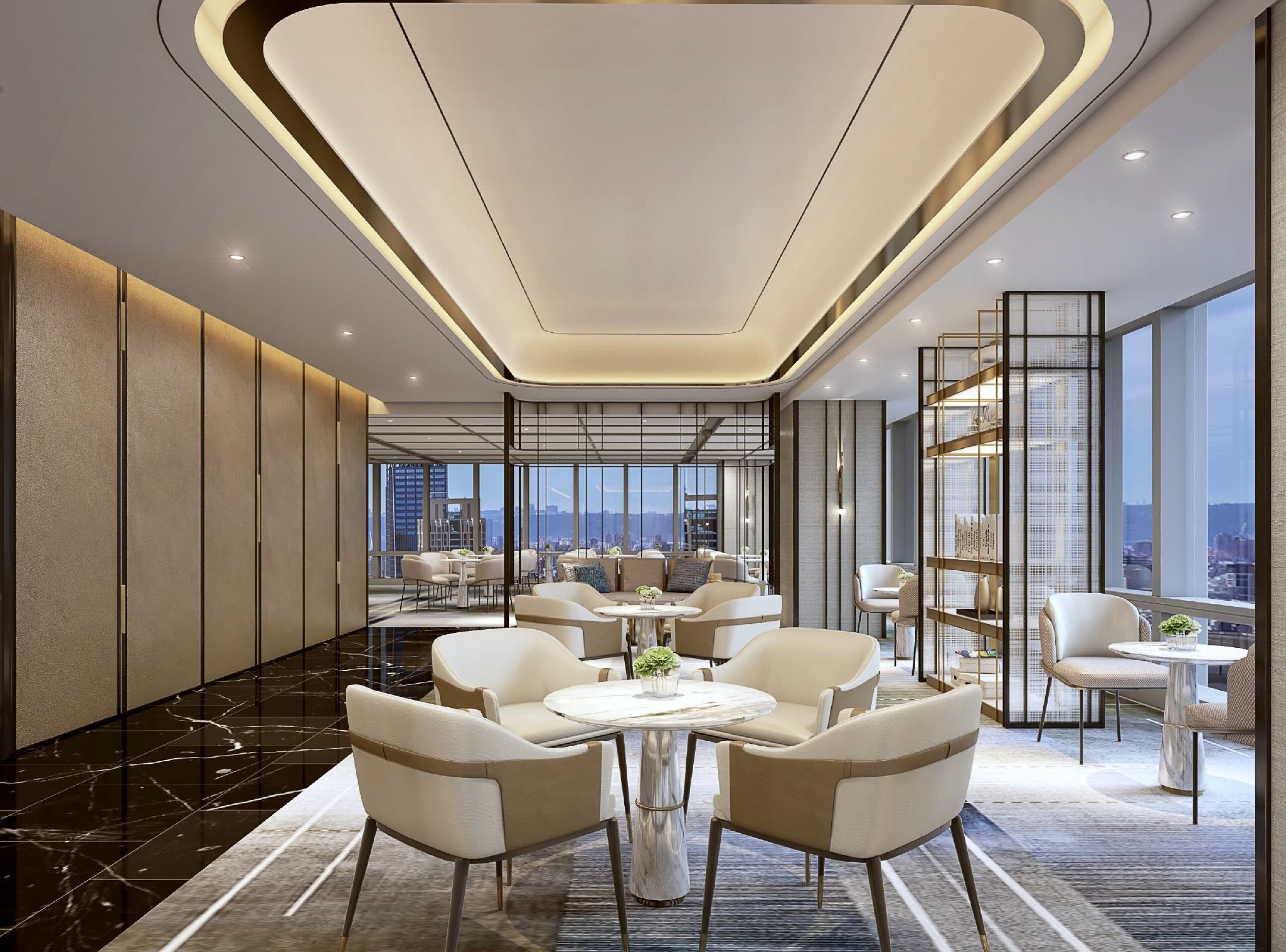 A modern hotel lobby with a high ceiling, marble flooring, and a city view. There are several seating areas with round tables and chairs.