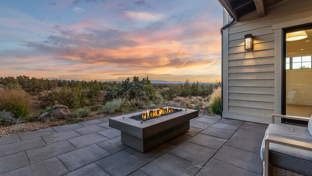 An outdoor patio with a fire feature, a seating area, and a view of the landscape. - Brasada Ranch | High Desert Modern Luxury | Sauna (Powell Butte)