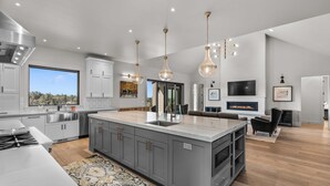 A modern kitchen with a large island, stainless steel appliances, and pendant lighting. - Brasada Ranch | High Desert Modern Luxury | Sauna (Powell Butte)