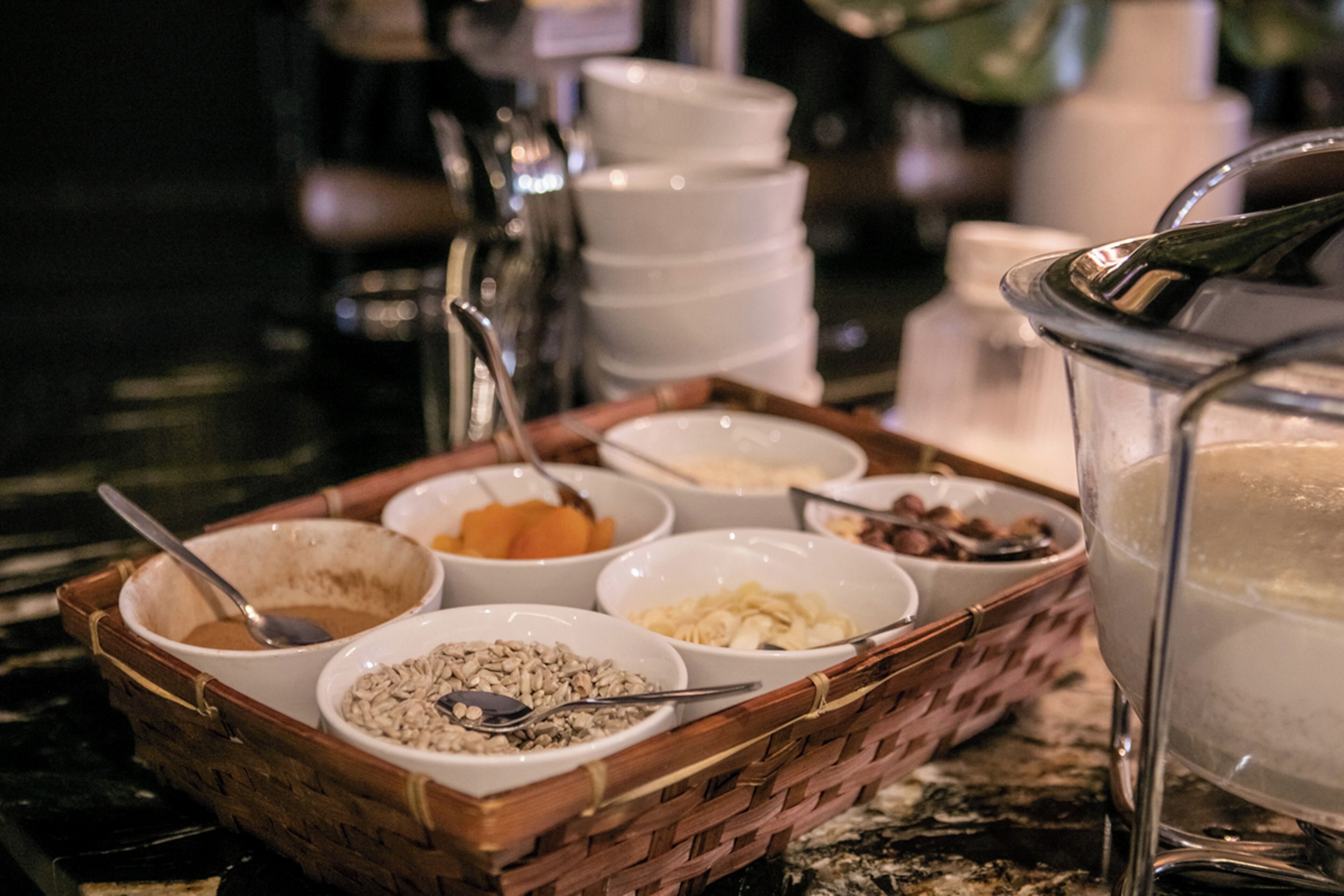 A buffet setup with various food items in bowls and a large pitcher of water.