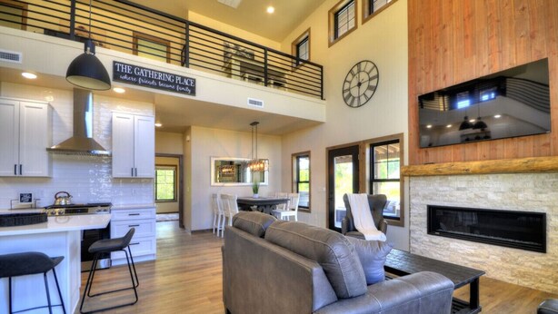 A spacious living area with a fireplace, a dining area, and a kitchen.