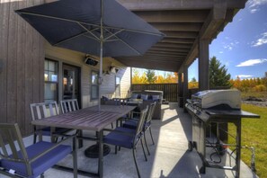 An outdoor patio with a table and chairs, a grill, and a covered area with a ceiling. - Summit Sky Retreat, Red Lodge (Red Lodge)