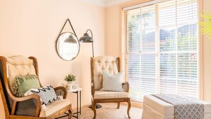 Relax in a comfortable seating area with a cushioned chair and sofa, a small table, and a potted plant.