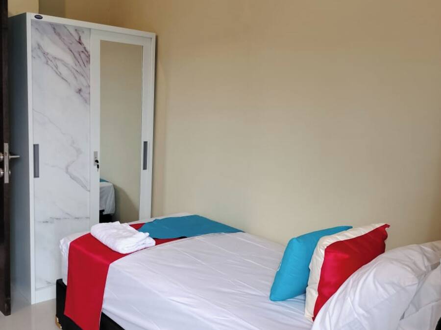 Un dormitorio con cama, armario y espejo.