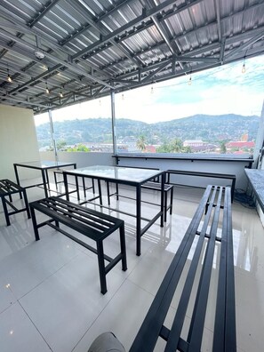 Un balcón amplio con vistas despejadas a un paisaje urbano y montañas.