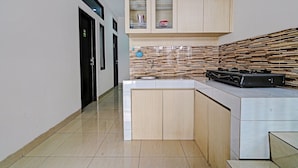Una cocina moderna con isla integrada, armarios de madera y salpicadero de azulejos.