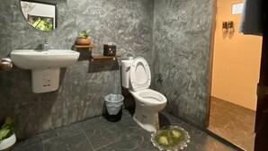 Un baño con inodoro, lavamanos y espejo.