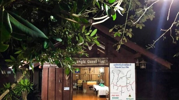 Una estructura de madera con un letrero que dice "Jungle Guest House" y un mapa que indica "WiFi gratuito, Internet, sin escala".