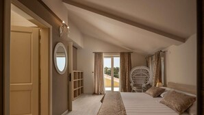 Un dormitorio con una cama grande, un armario, un espejo redondo y vistas al exterior.