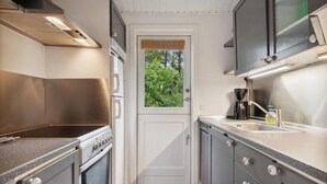A compact kitchen with a stove, oven, microwave, and a coffee maker. - Nice home in ålbæk with WiFi (Ålbæk)