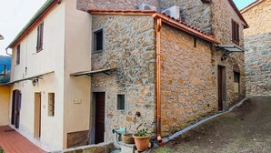 A stone building with a tiled roof, a small porch, and a potted plant. - Lovely home in Marliana with WiFi (Marliana)