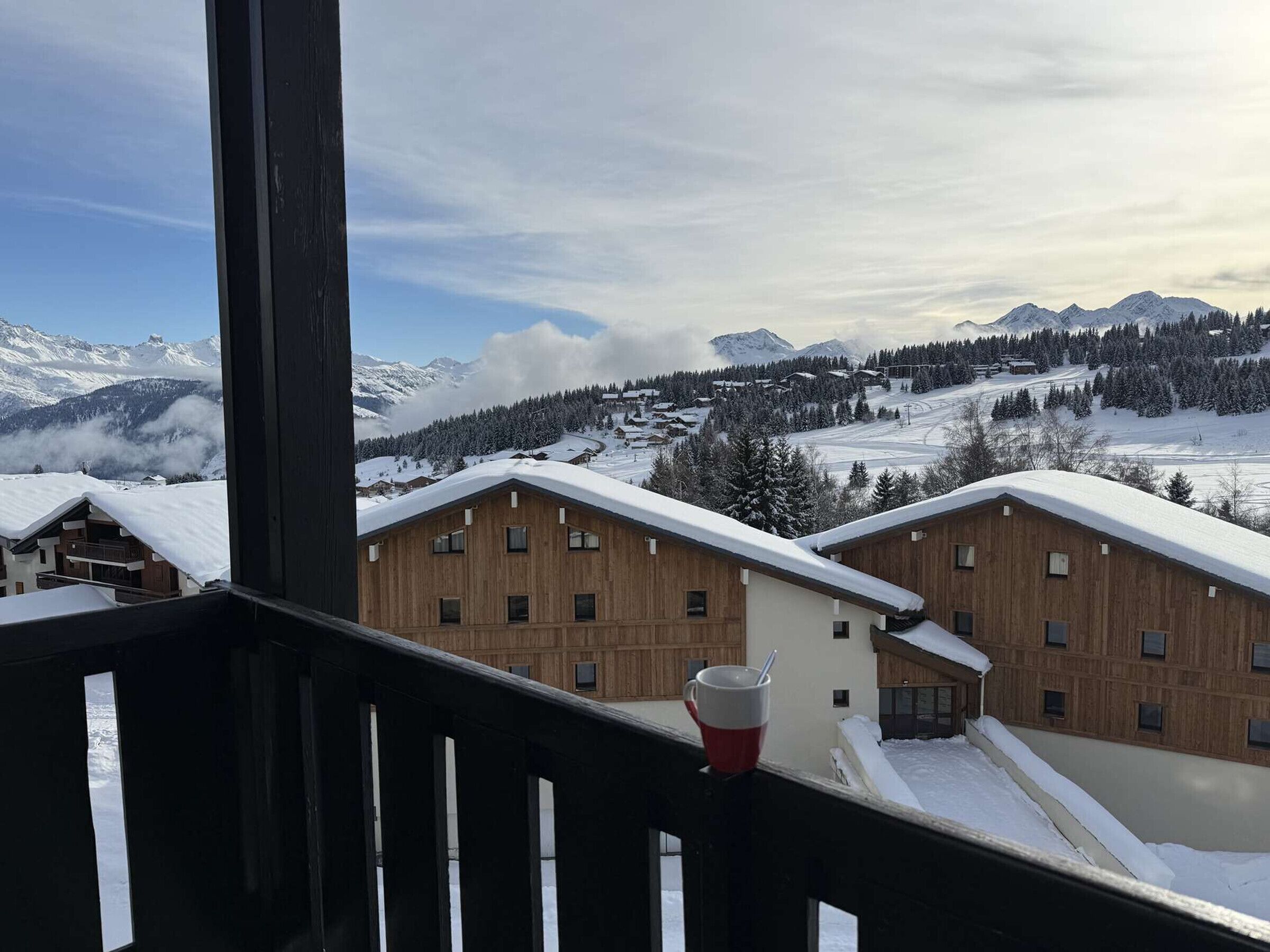 A wooden building with multiple windows and a balcony with a red and white cup.
