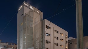 Un hôtel au design moderne, avec une grande enseigne « HÔTEL » bien visible sur sa façade.