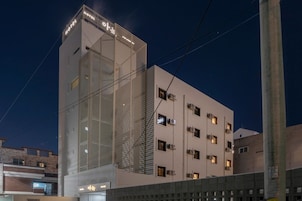 Un hotel de diseño moderno, con un llamativo letrero que dice 'HOTEL' en la parte superior.