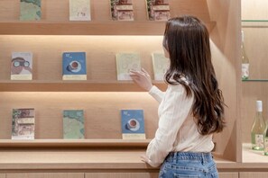 Eine Person betrachtet eine Buchausstellung an einem Regal.