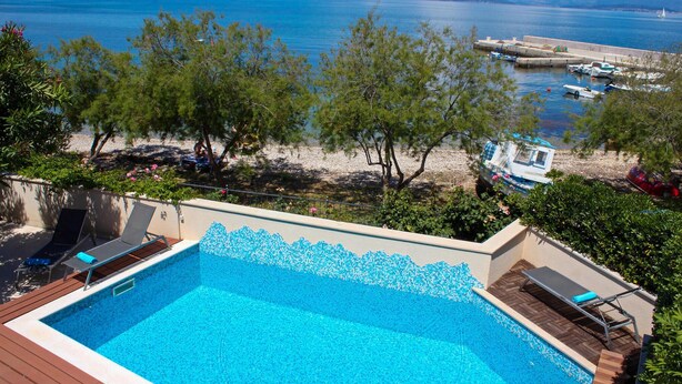 A swimming pool with a view of the sea and boats. - Luxurious home in Supetar (Supetar)