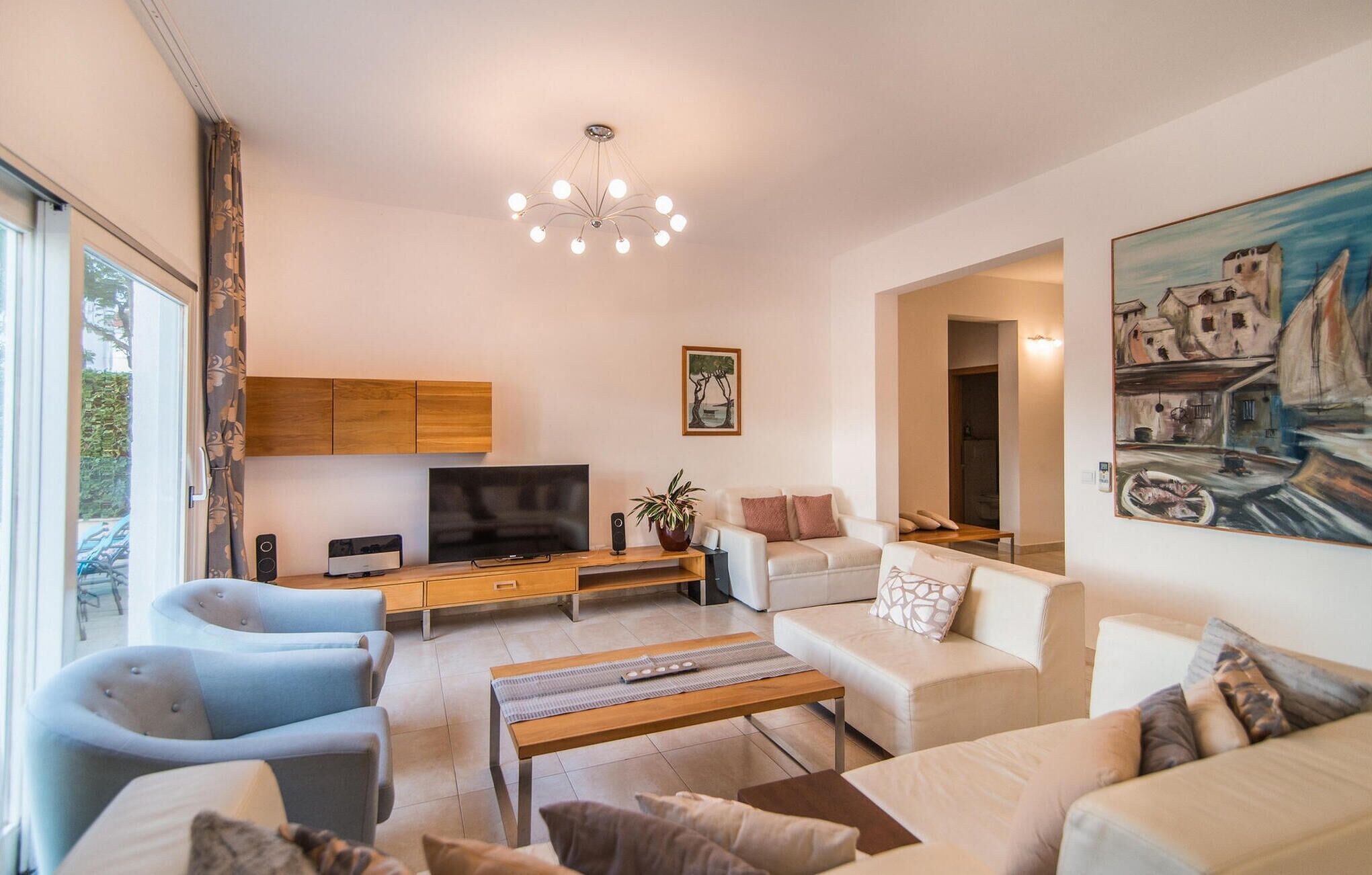 A modern living room with a flat-screen TV, a wooden coffee table, and a sofa.