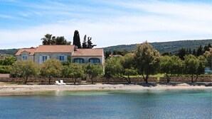 A coastal property with a large house, a beach, and clear waters. - Luxurious home in Supetar (Supetar)